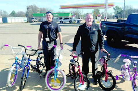 Doug Chaffin and Blake Johnson are pictured with 6 bicy - cles that the Holdenville Muscogee Nation Casino gave out to 6 lucky children in Wetumka.
