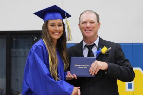 Moss school board member Bryan Smith presents diplomas