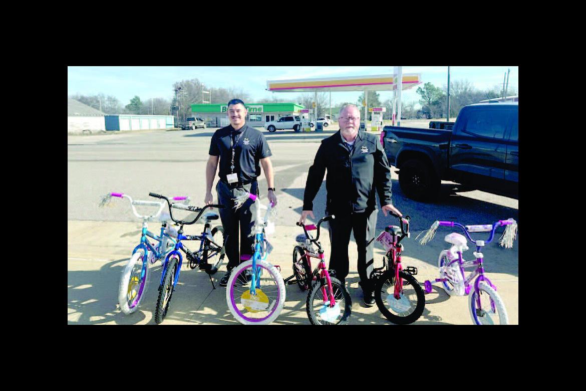 Doug Chaffin and Blake Johnson are pictured with 6 bicy - cles that the Holdenville Muscogee Nation Casino gave out to 6 lucky children in Wetumka.